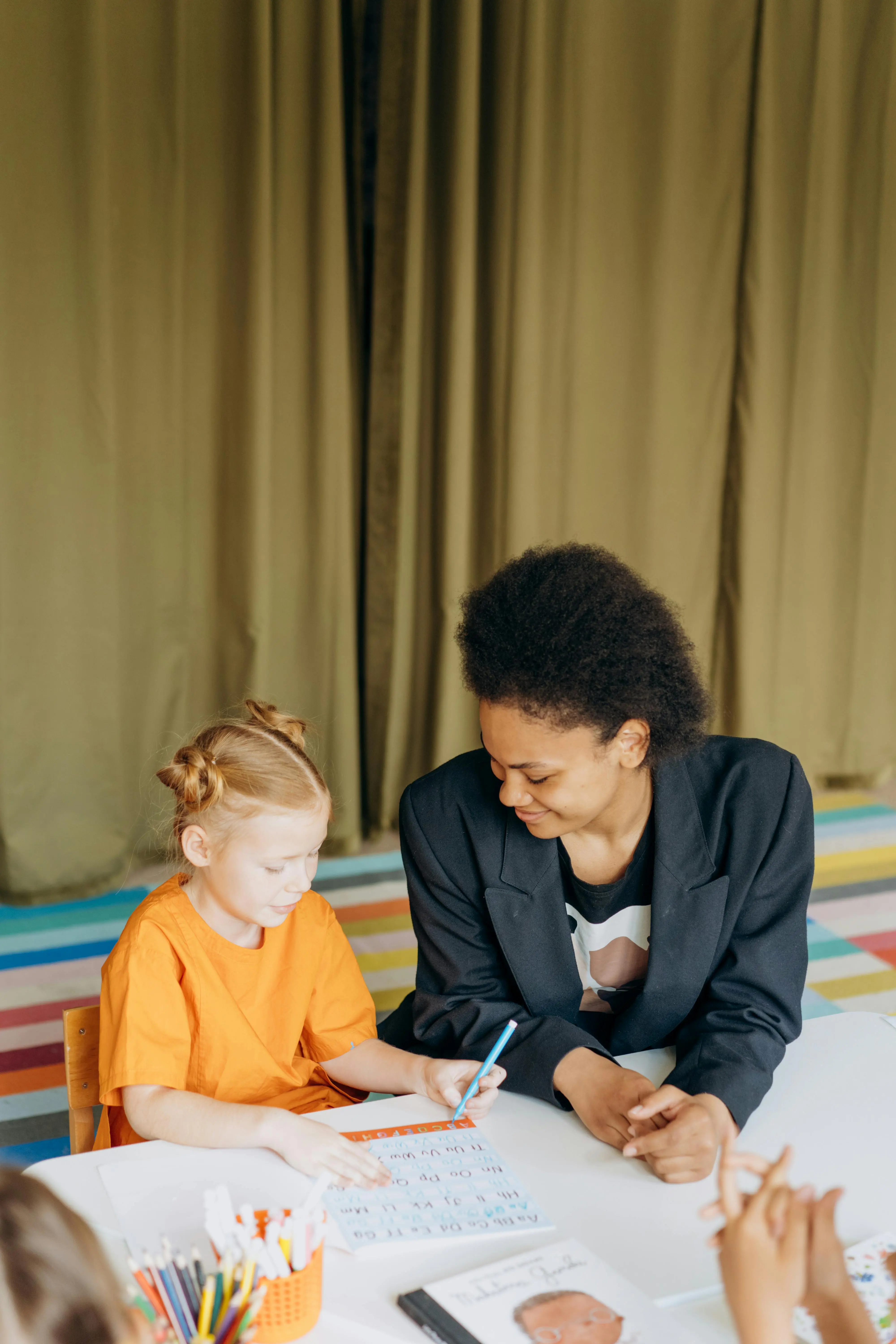 Teacher helping a young student practise handwriting